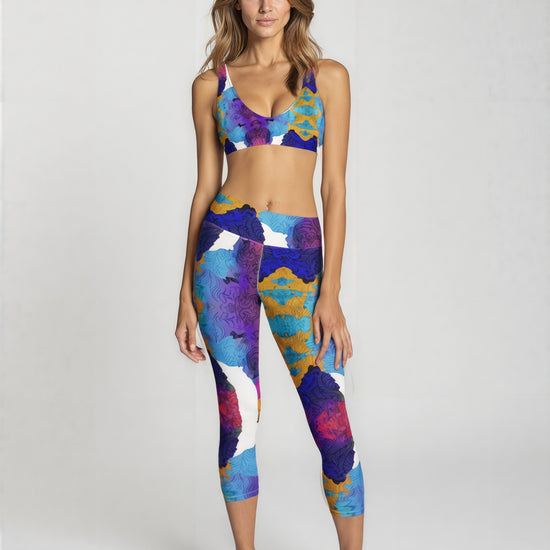 Front view of high-waisted Ocean Mirage Yoga Capri Leggings in ocean-inspired abstract blue, purple, and gold print, shown on a model’s capri-length fit.