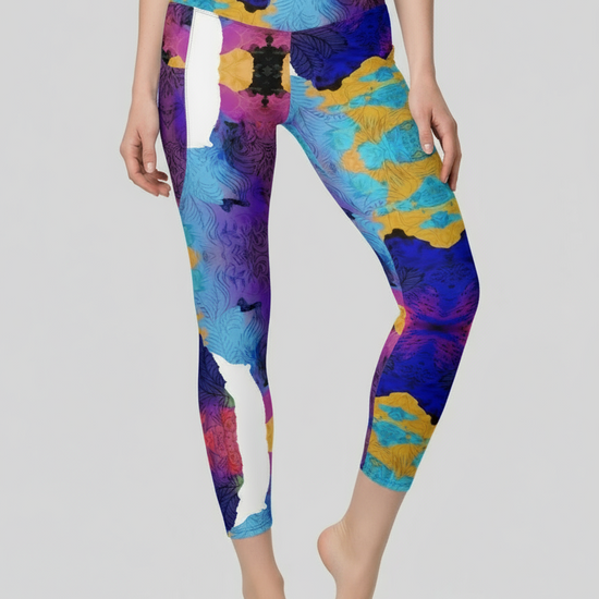 Colorful abstract-patterned leggings worn by a person on a plain background
