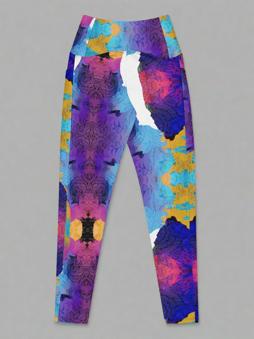 Ocean Mirage Crossover leggings laid flat, back view, showcasing high waistband and symmetrical multicolour abstract pattern with purple, blue, yellow, pink, and black tones on a grey background.