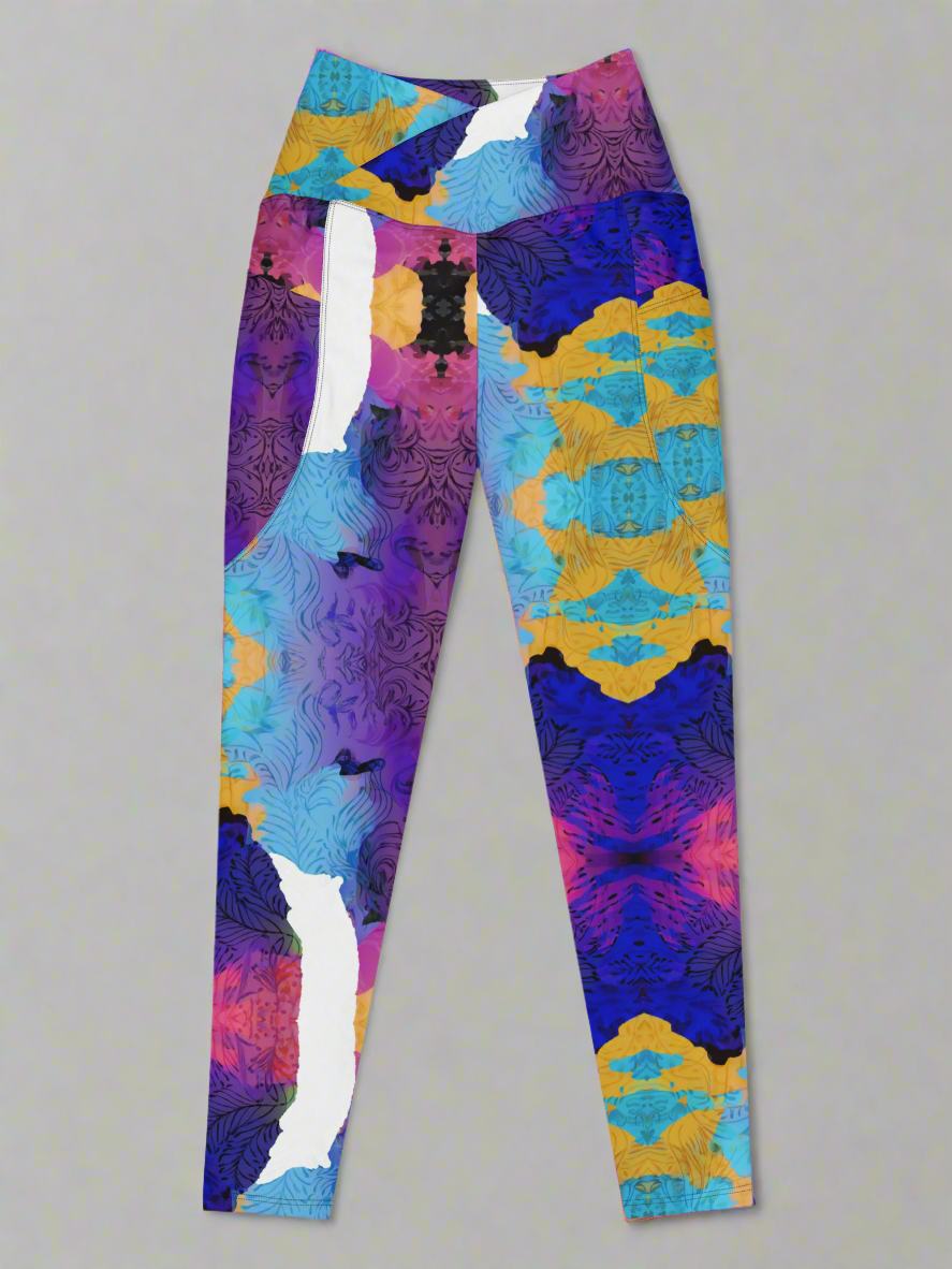 Ocean Mirage Crossover leggings laid flat, front view, featuring a high waistband and vibrant abstract print in purple, blue, yellow, pink, and black on a grey background.