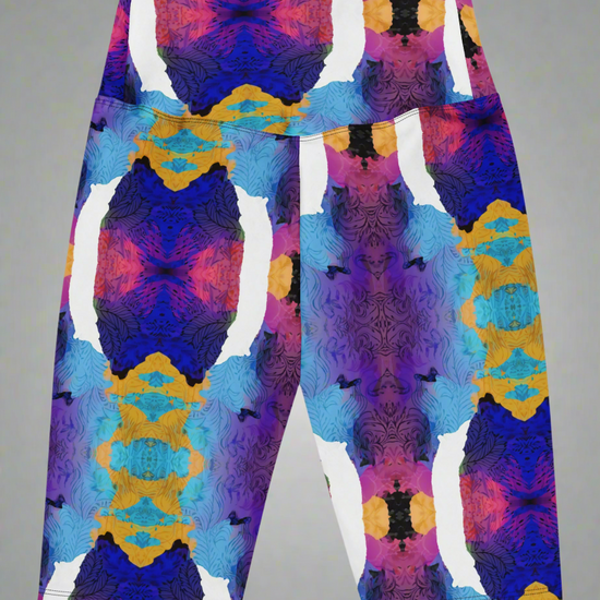 Back view, flat-lay of Ocean Mirage Biker Shorts featuring a vibrant abstract pattern in deep blue, purple, pink, orange, black, and white; displayed flat against a neutral grey background to highlight the bold kaleidoscopic design.
