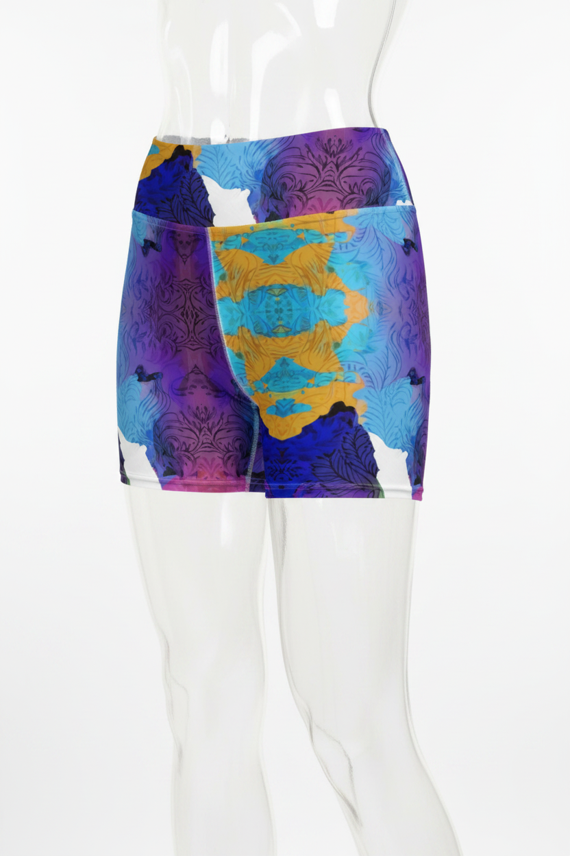A mannequin wearing high-waisted athletic shorts with a bold abstract print in purple, blue, yellow, and white on a plain white background.