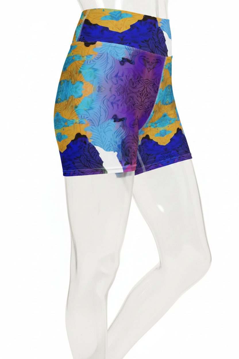 A mannequin wearing high-waisted athletic shorts with a vibrant abstract print in blue, purple, yellow, and white, shown from the waist down against a plain white background.