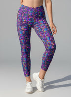 Person wearing colorful geometric patterned leggings on a gray background