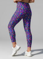 Multicolored geometric patterned leggings worn by a person on a gray background