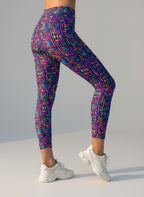 Multicolored geometric patterned leggings worn by a person on a gray background