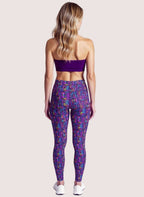 Woman wearing a purple sports bra and leggings with a geometric pattern on a white background