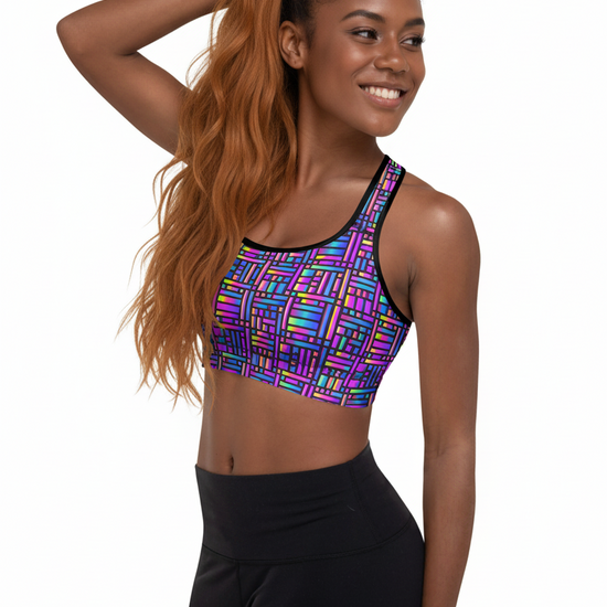 Woman wearing a colorful sports bra and black leggings on a white background