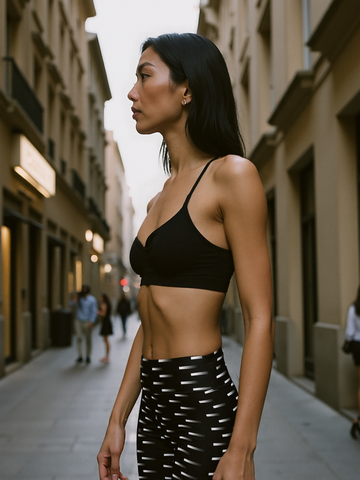 Woman wearing a black sports bra and patterned Pixie and Sherbet Nightfall Edit Yoga leggings on a city street.