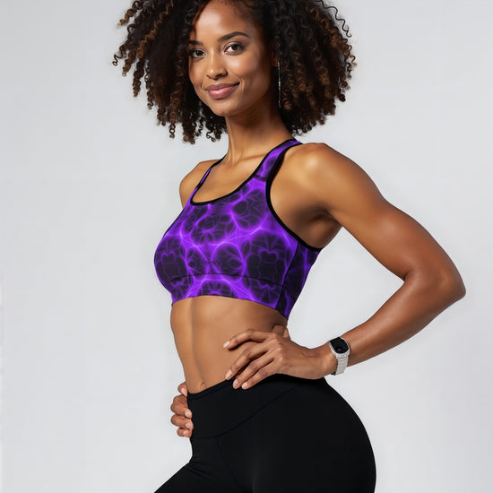 Woman wearing Violet Voltage Essential Active Bra with a bold purple and black electric floral pattern, standing confidently against a plain background