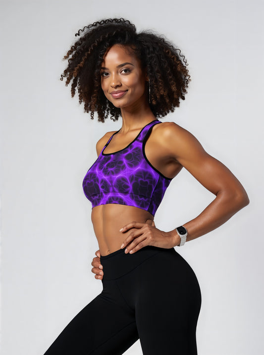 Woman wearing Violet Voltage Essential Active Bra with a bold purple and black electric floral pattern, standing confidently against a plain background