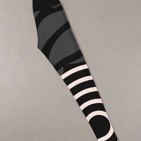 Right side flat lay view of colourful abstract patterned leggings on a grey background