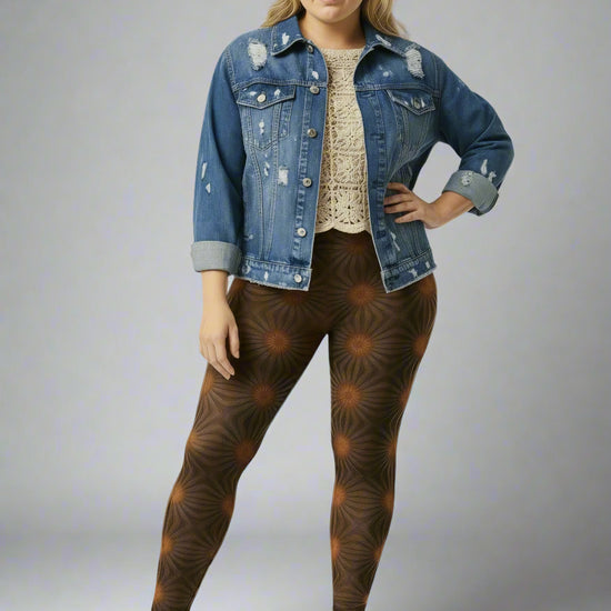 Women’s Rustic Amber yoga leggings brown radial geometric print styled with a cream crochet top, blue distressed denim jacket, and brown double-strap sandals against a pale gray backdrop.