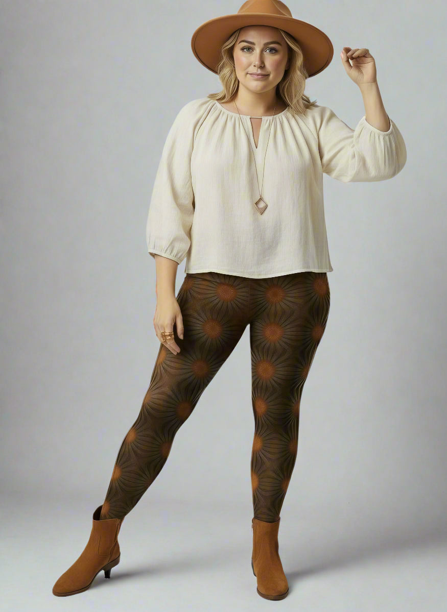 Women’s Rustic Amber yoga leggings brown radial geometric print styled with a cream long-sleeve keyhole blouse, wide-brim brown hat and brown ankle boots against a pale backdrop.