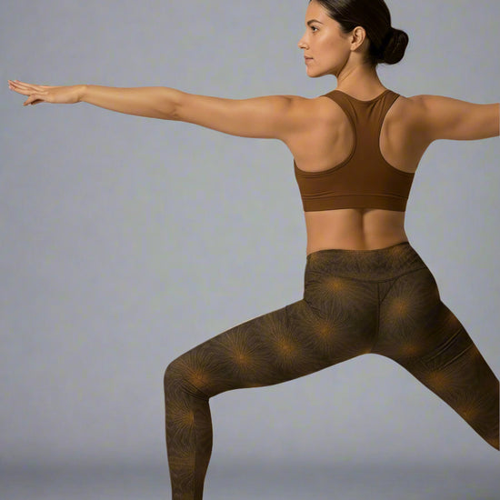 Woman in brown sports bra and leggings posing against a light gray background