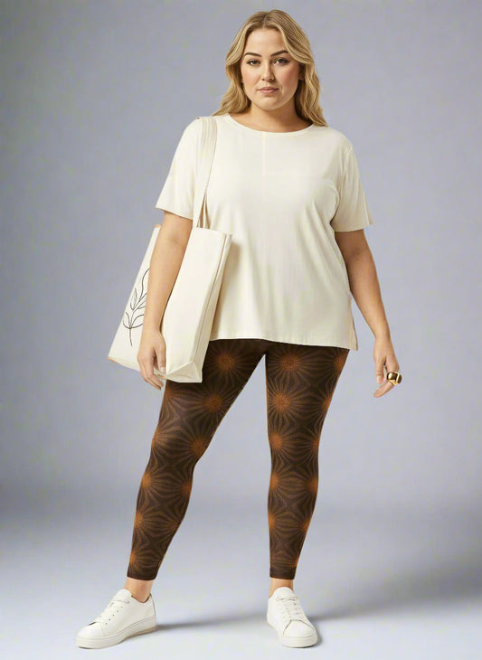 Women’s Rustic Amber yoga leggings, brown with amber geometric starburst print, paired with a cream tee, white sneakers and cream tote against a pale gray backdrop.