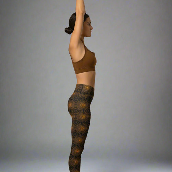 Person wearing a brown sports bra and patterned leggings against a gray background