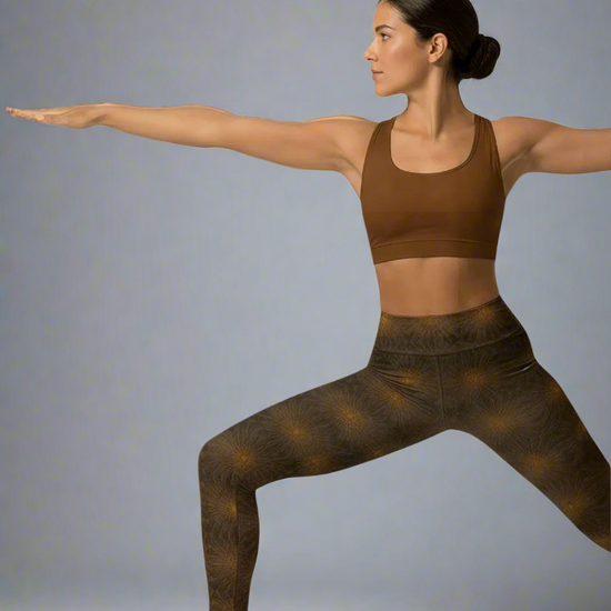 Woman in brown sports bra and leggings posing against a gray background