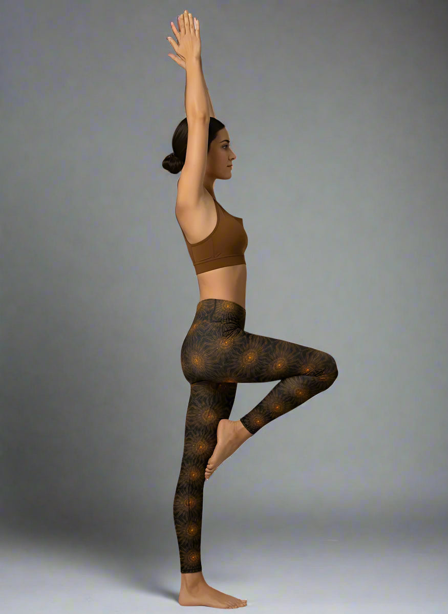 Person wearing a brown sports bra and patterned leggings performing a yoga pose on a gray background