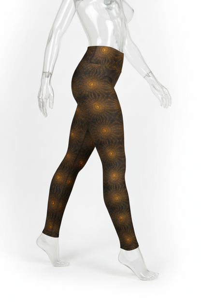 A mannequin modeling high-waisted leggings with a dark brown and black abstract pattern accented by glowing golden-yellow circular motifs, shown from a side-back angle against a plain white background.