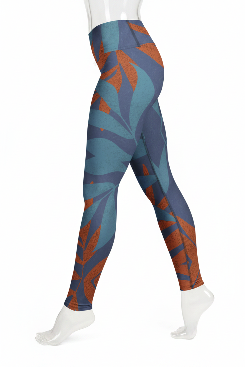 A mannequin modeling high-waisted leggings with a blue and rust-orange tropical leaf pattern against a plain white background.