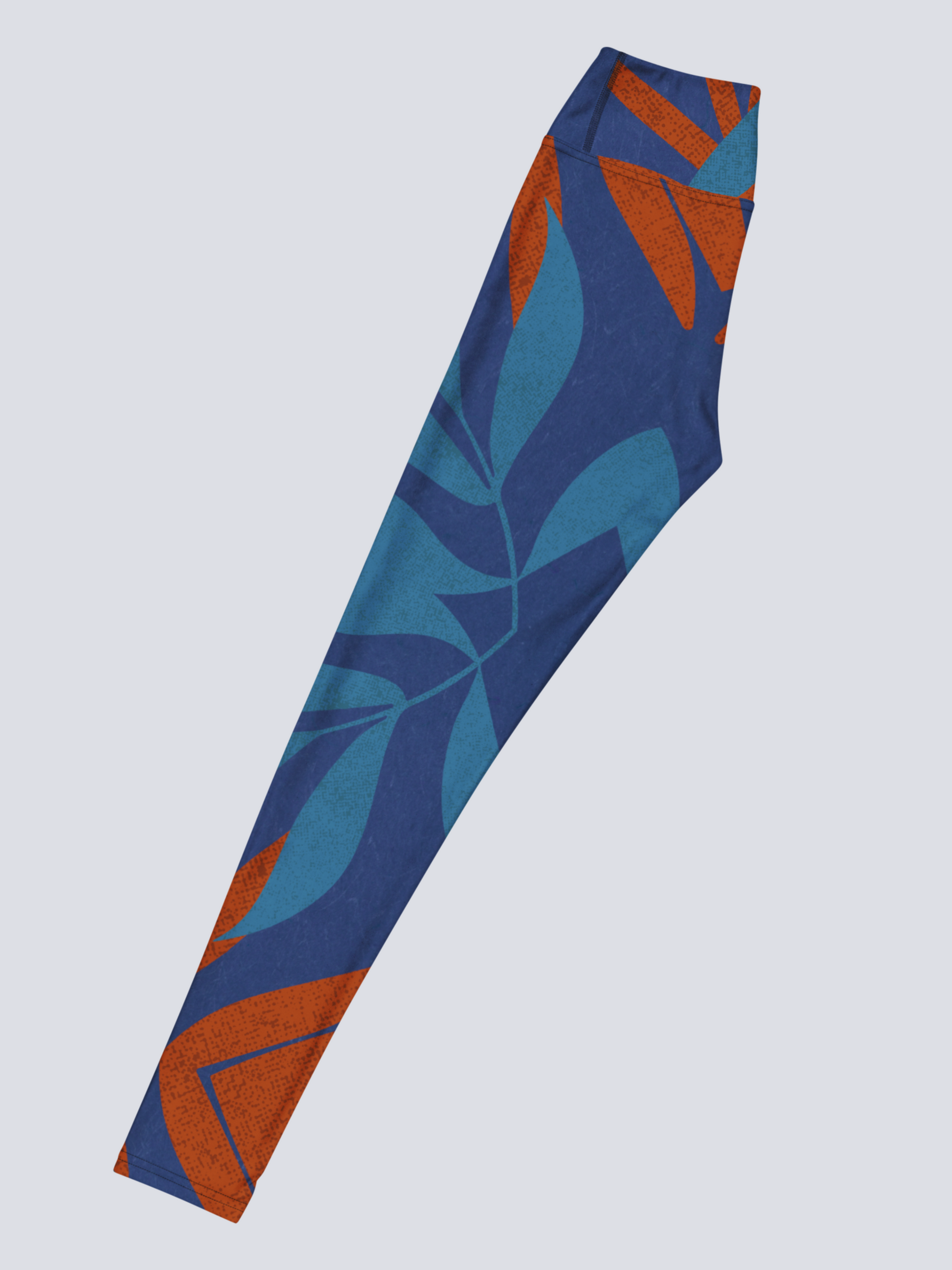 Left side of blue and burnt orange patterned yoga legging on a light grey background