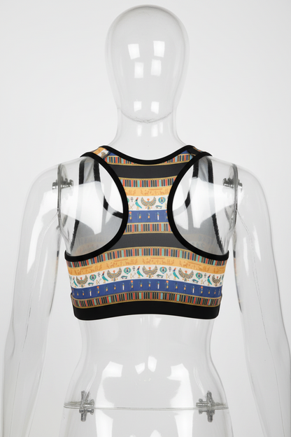 A racerback-style crop top with a colorful horizontal pattern featuring blue, gold, beige, and black stripes, along with stylized bird motifs, shown on a plain white background. 