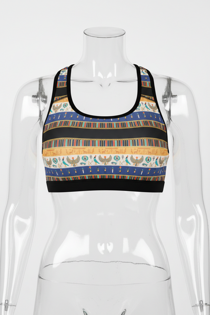 A racerback crop top featuring a horizontal striped Egyptian-inspired pattern with blue, gold, beige, and black bands, displayed on a solid white background. 
