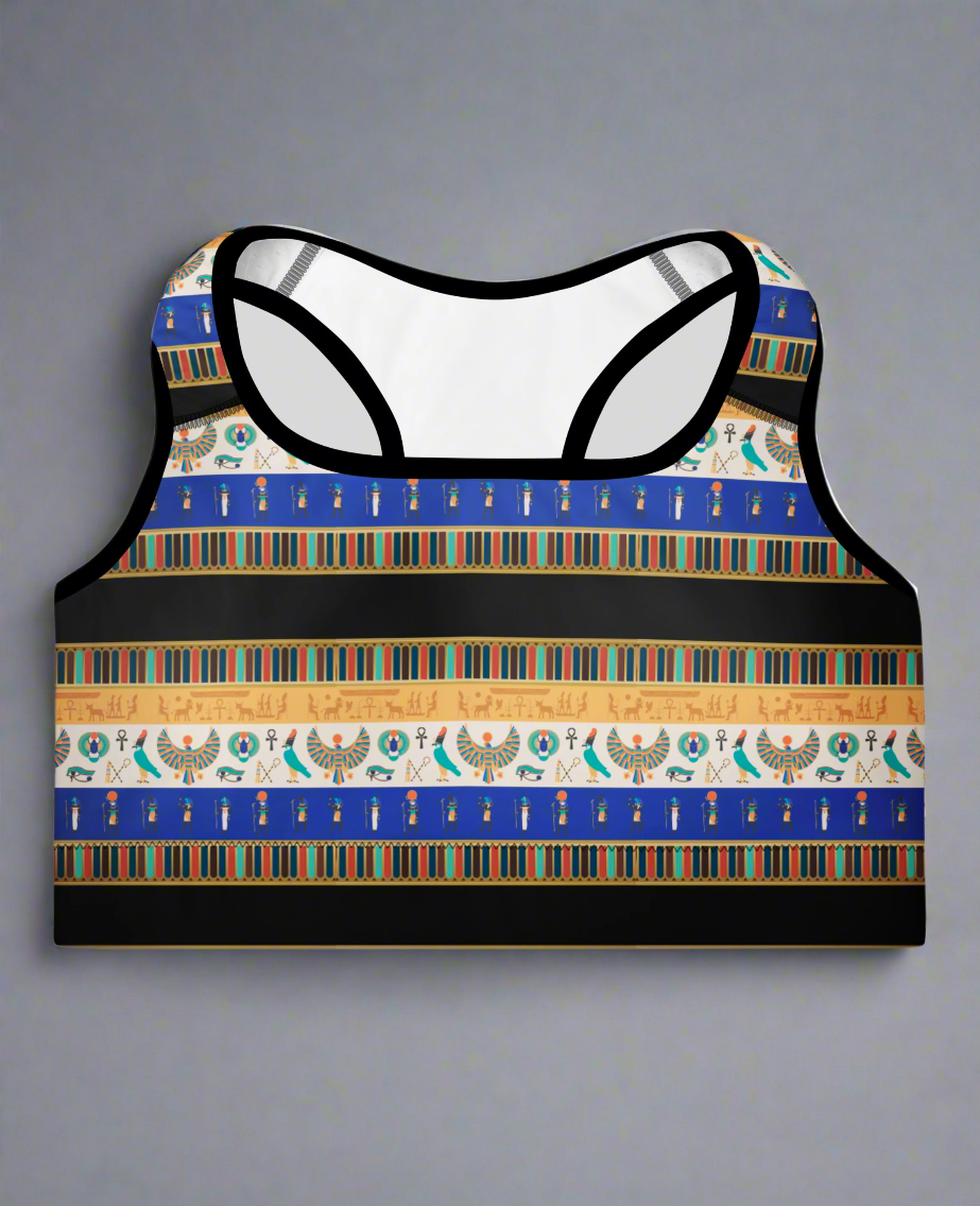 Front view of Sapphire Essential Active Bra featuring blue, gold, black, and white Egyptian-inspired pattern with hieroglyphics, Eye of Horus, and scarab motifs; displayed against a plain background.