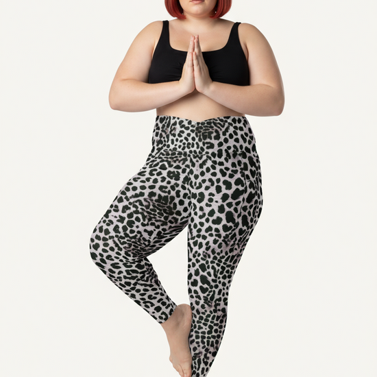 Woman wearing black tank top and leopard print leggings on a white background