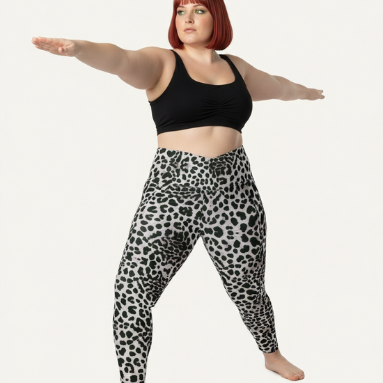 Person wearing black tank top and leopard print leggings on a white background