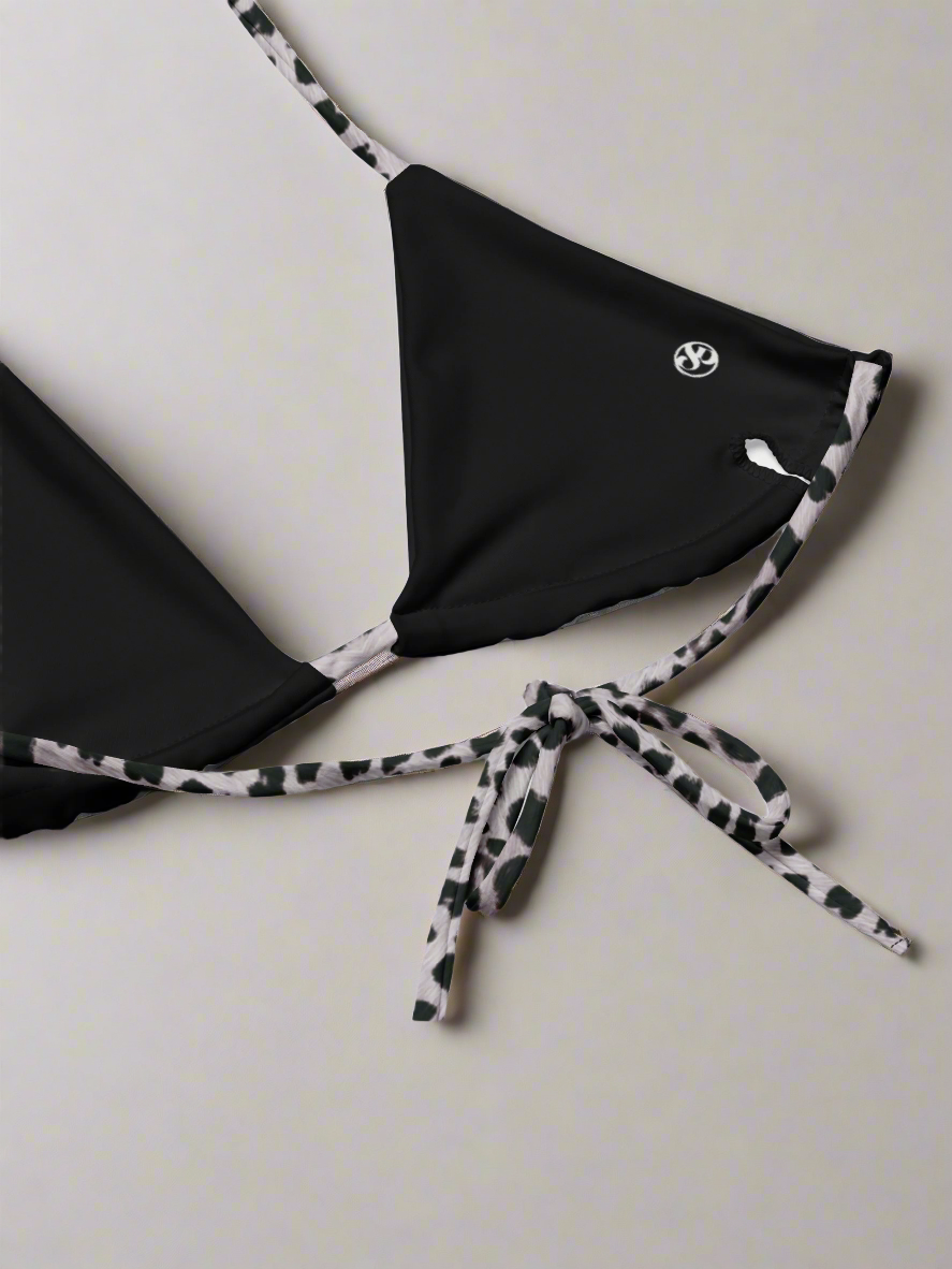Empowering black triangle bikini top with bold Savannah Charge print straps, luxe logo accent, and adjustable tie-back fit—styled on a clean backdrop for modern contrast