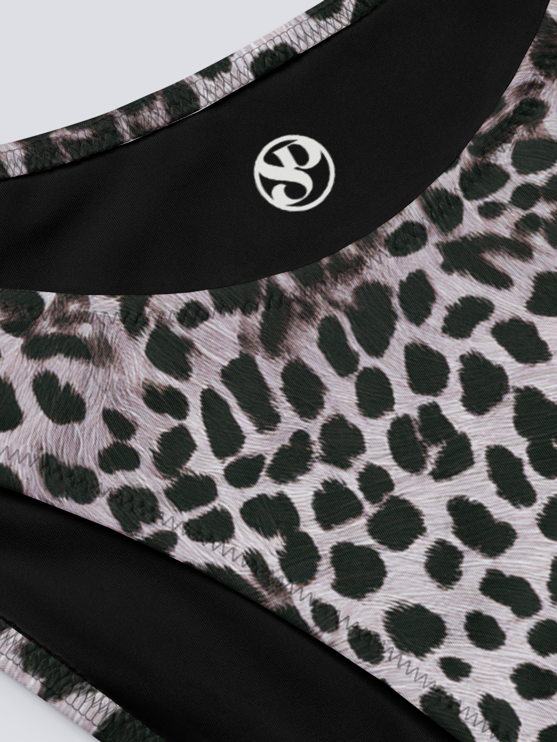 Close-up of Savannah Charge Cheeky Bikini Bottoms in monochrome leopard print, featuring Pixie & Sherbet logo and detailed stitching – bold, sculpting swimwear.