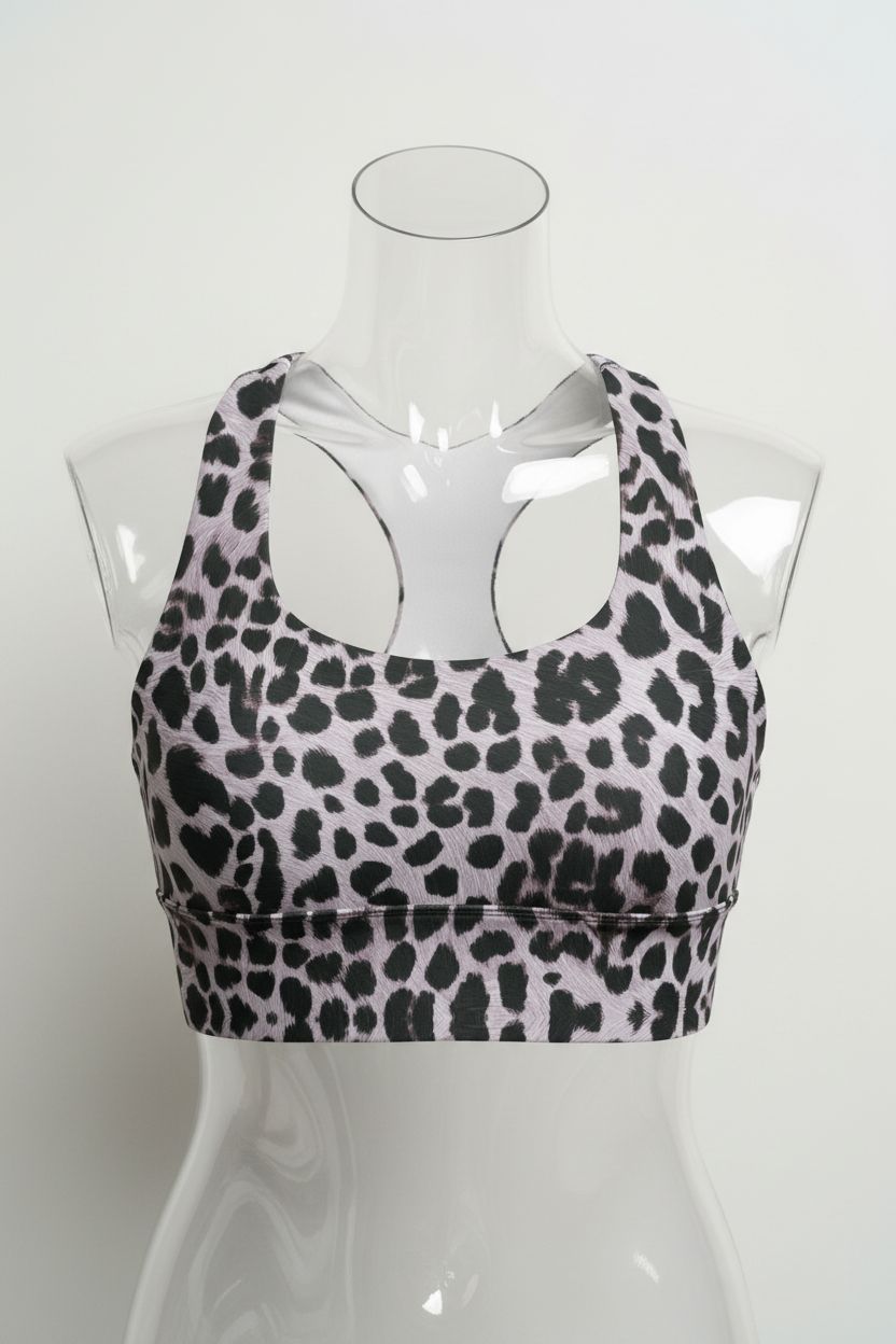 A sports bra with a black leopard print pattern on a light gray background, featuring a white inner lining and racerback straps.