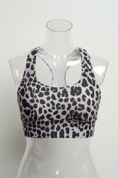 A sports bra with a black leopard print pattern on a light gray background, featuring a white inner lining and racerback straps.