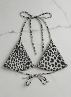 Leopard print bikini top and bottom on a marble background