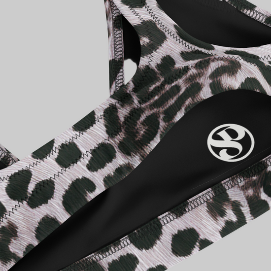 Savannah Charge Surf bikini top in luxe leopard print with contrast black panels and white logo detail; high-performance stretch fabric with sleek stitching for a bold, empowering beach-to-studio look