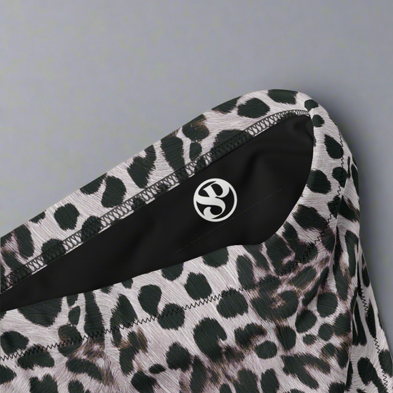 Leopard print fabric with a brand logo on a light gray background