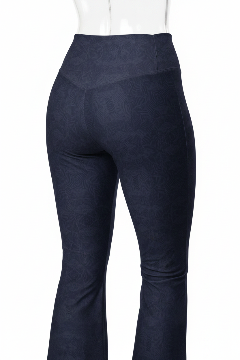 Close-up back view of a mannequin wearing high-waisted navy leggings with a subtle tonal geometric pattern and a white long-sleeve top against a light gray background.