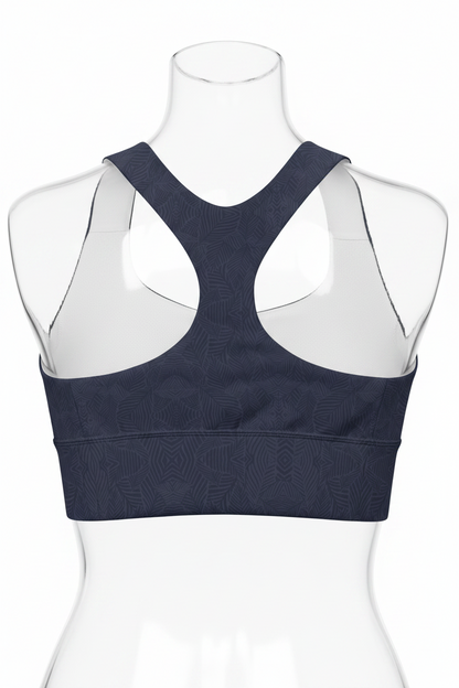 A women's sports bra shown from the back, featuring a dark navy blue body with a subtle tonal geometric pattern and contrasting white inner shoulder panels. 