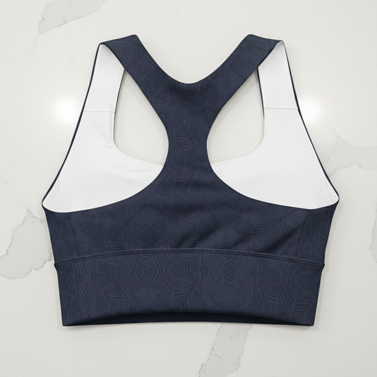 Navy sports bra with white mesh panels on a white background