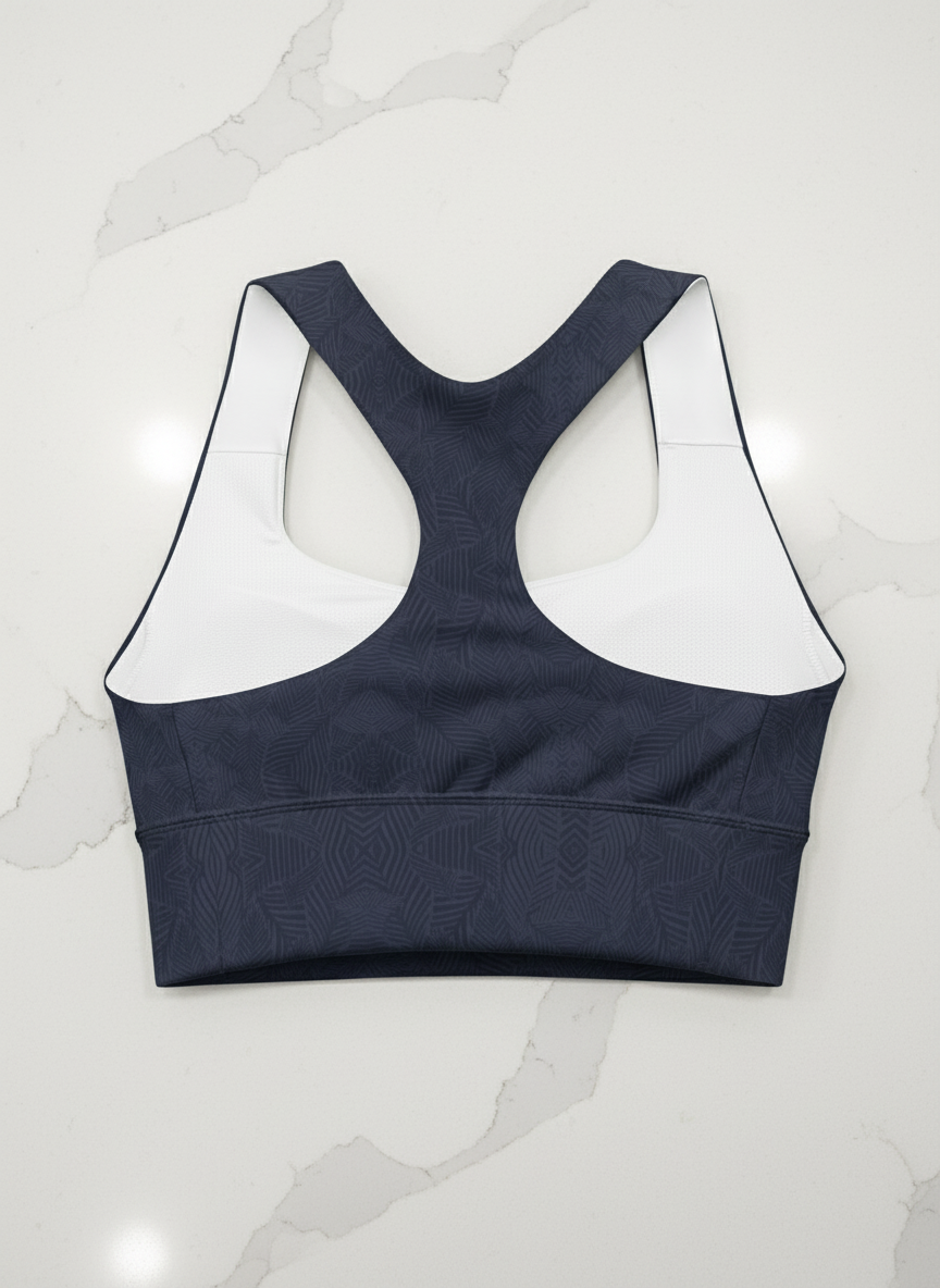 Navy sports bra with white mesh panels on a white background