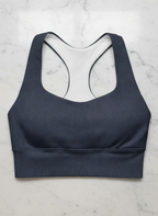 Navy blue sports bra with geometric pattern on a marble surface