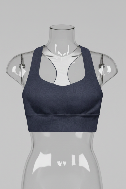 A women's sports bra in dark navy blue with a subtle tonal geometric pattern, featuring a white inner lining and racerback-style straps, shown against a plain white background. 