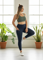 Woman in athletic wear posing in a room with plants