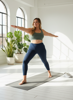 Woman practicing yoga in a bright, minimalistic room with plants.