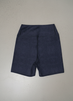 Back view of navy and blue, Shadow leaf Yoga shorts with gentle leaf pattern on a light grey background by Pixie and Sherbet.