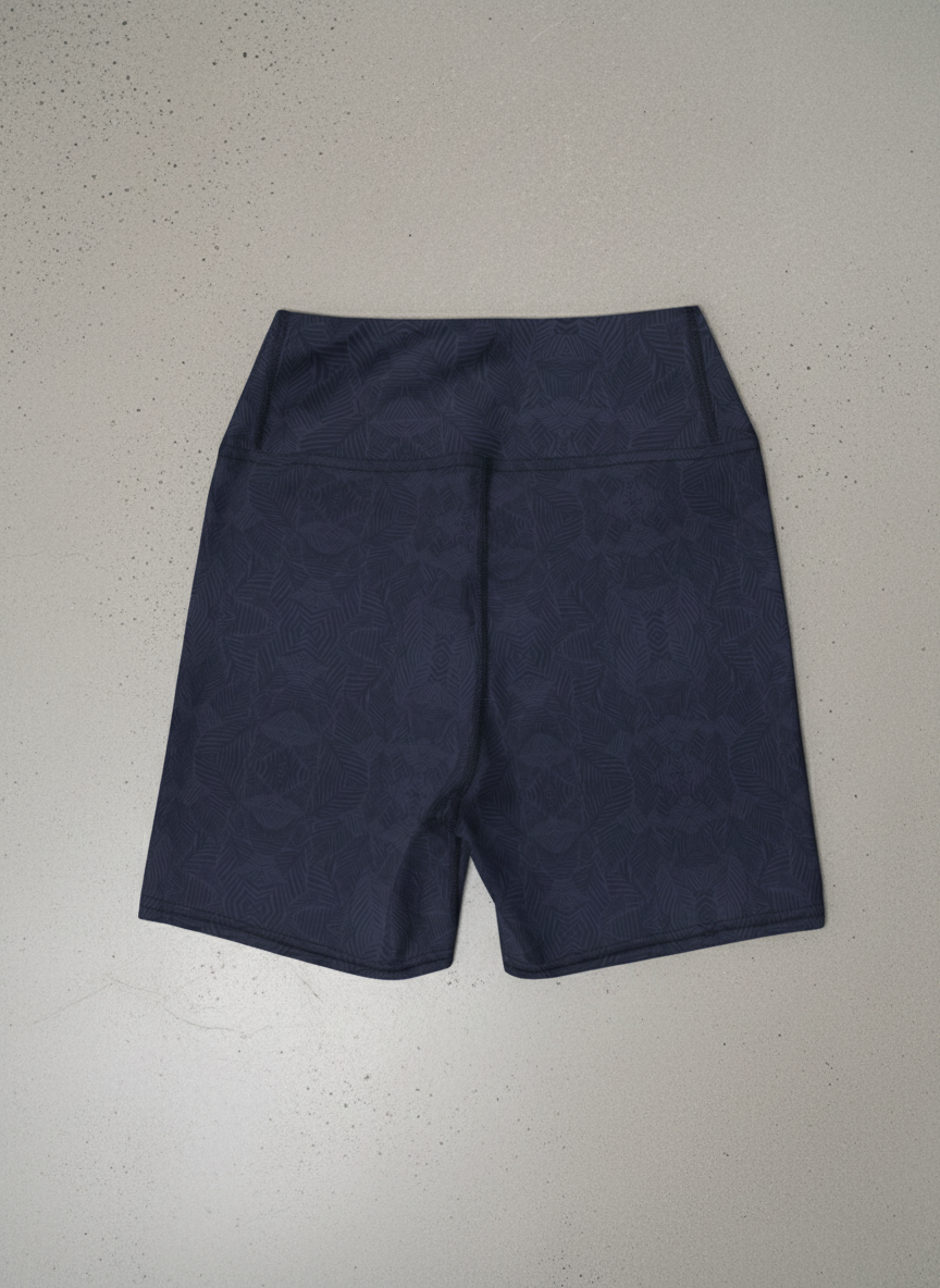 Back view of navy and blue, Shadow leaf Yoga shorts with gentle leaf pattern on a light grey background by Pixie and Sherbet.