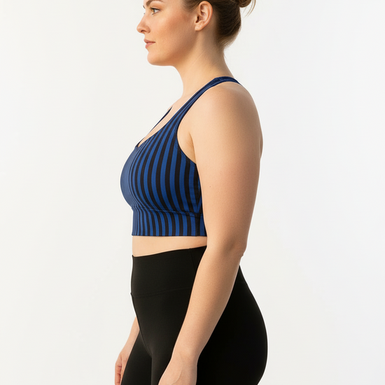 Woman wearing a blue striped sports bra and black leggings on a white background