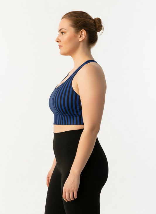 Woman wearing a blue striped sports bra and black leggings on a white background